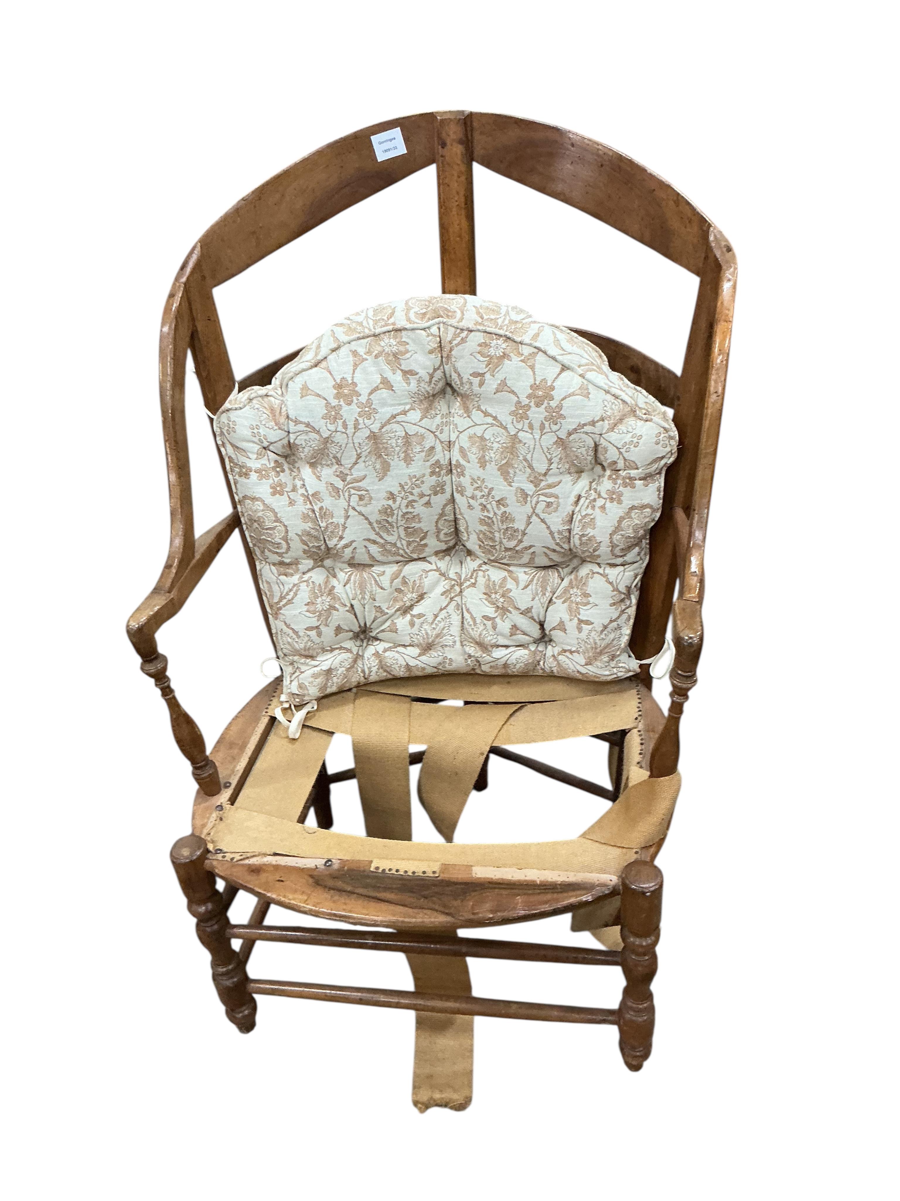 A 19th century French fruitwood armchair, width 70cm, depth 64cm, height 112cm and foot stool